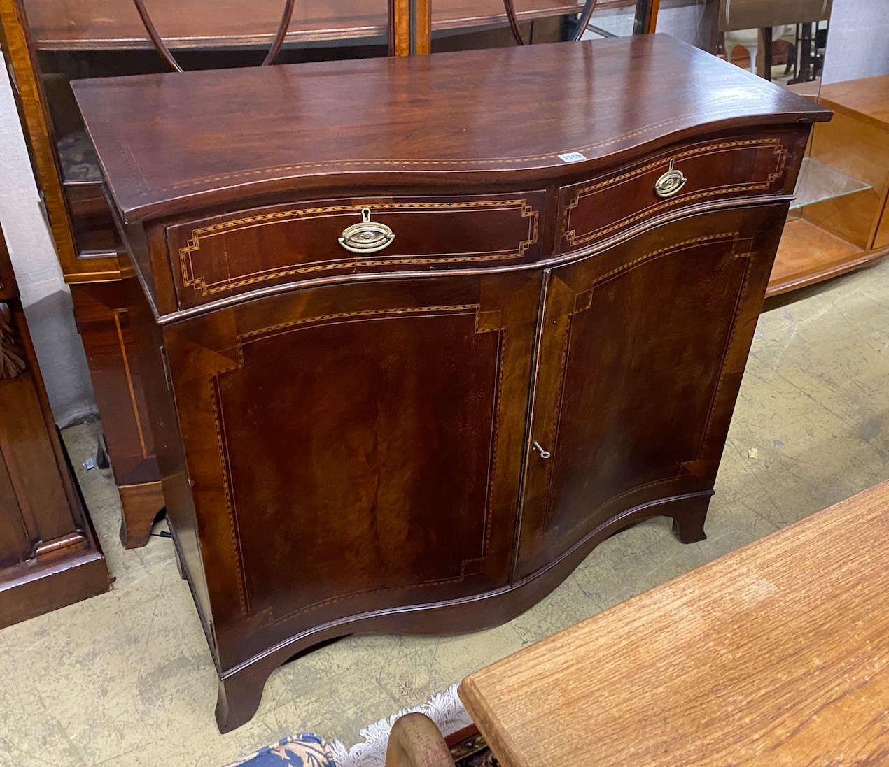 An Edwardian inlaid mahogany serpentine side cabinet, width 103cm, depth 48cm, height 96cm